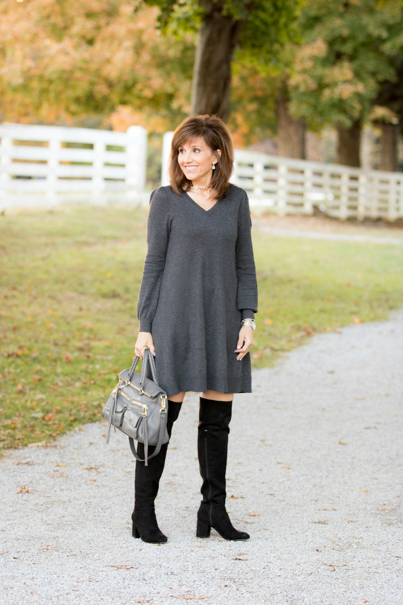 Fashion blogger Cyndi Spivey styling a sweater dress from Loft.