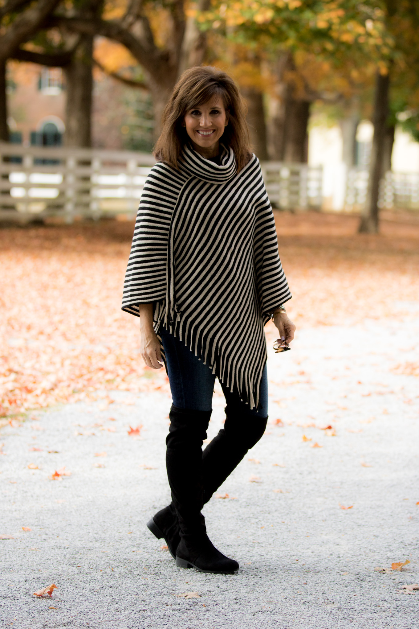 Fashion blogger, Cyndi Spivey, styling a striped poncho from Glamour Farms Boutique.
