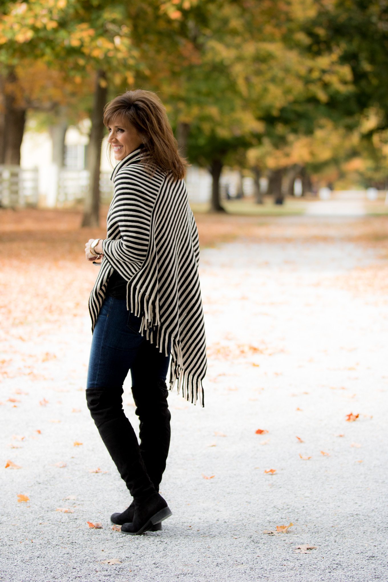 Fashion blogger, Cyndi Spivey, styling a striped poncho from Glamour Farms Boutique.