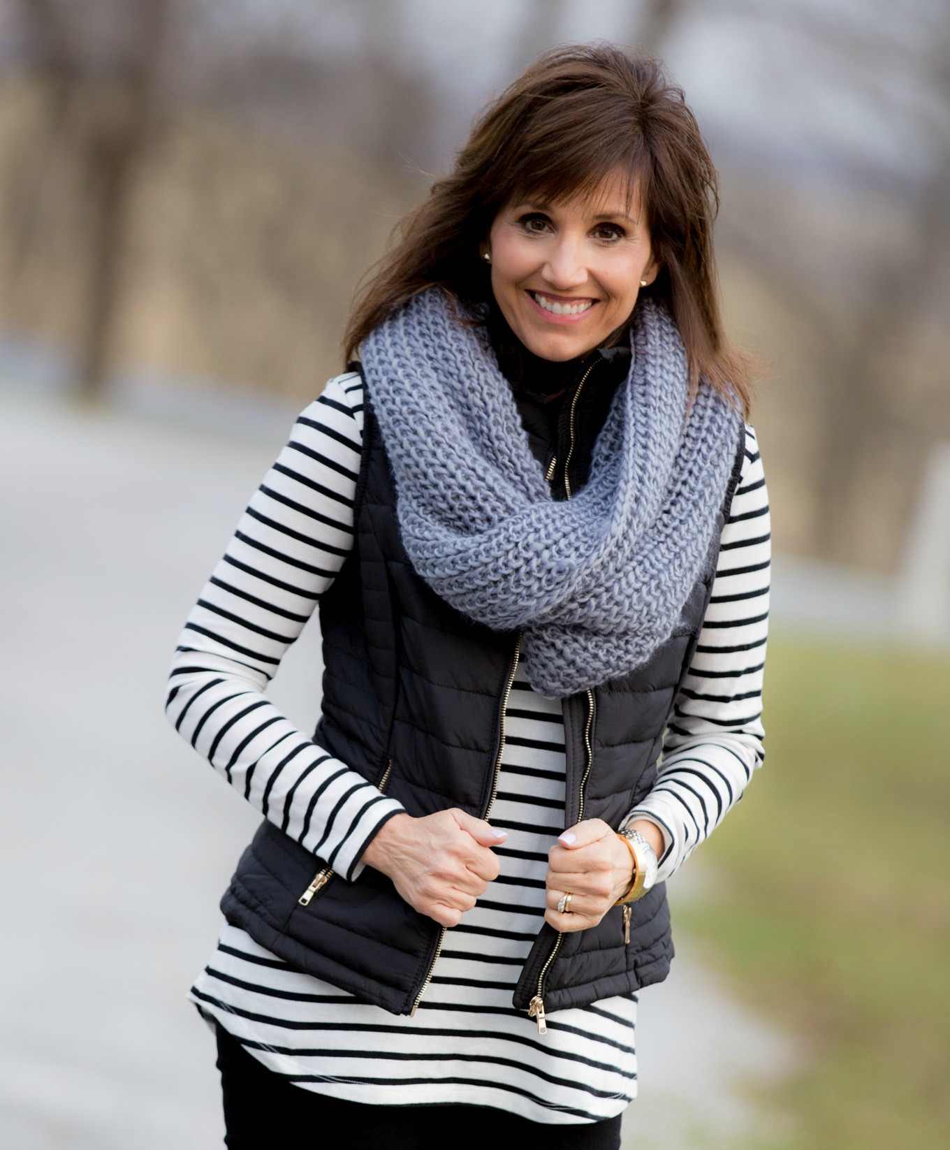 Over 40 fashion blogger, Cyndi Spivey, styling a black quilted vest.