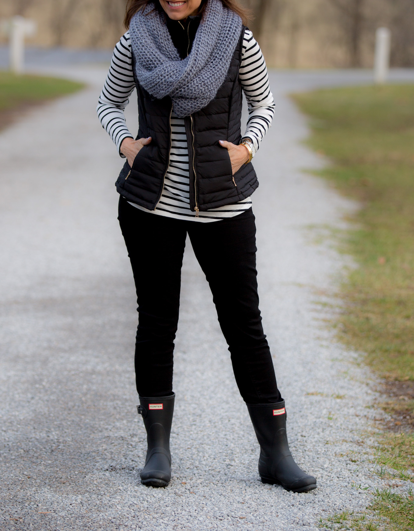 Over 40 fashion blogger, Cyndi Spivey, styling a black quilted vest.
